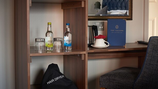 A hotel room with a minibar, a microwave, a coffee maker, and a book titled "The Falcon". - The Falcon Hotel & Restaurant (Bridgnorth)