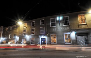 Un edificio con múltiples ventanas y un letrero que dice 'The Falcon Hotel, Restaurant & Bar'.