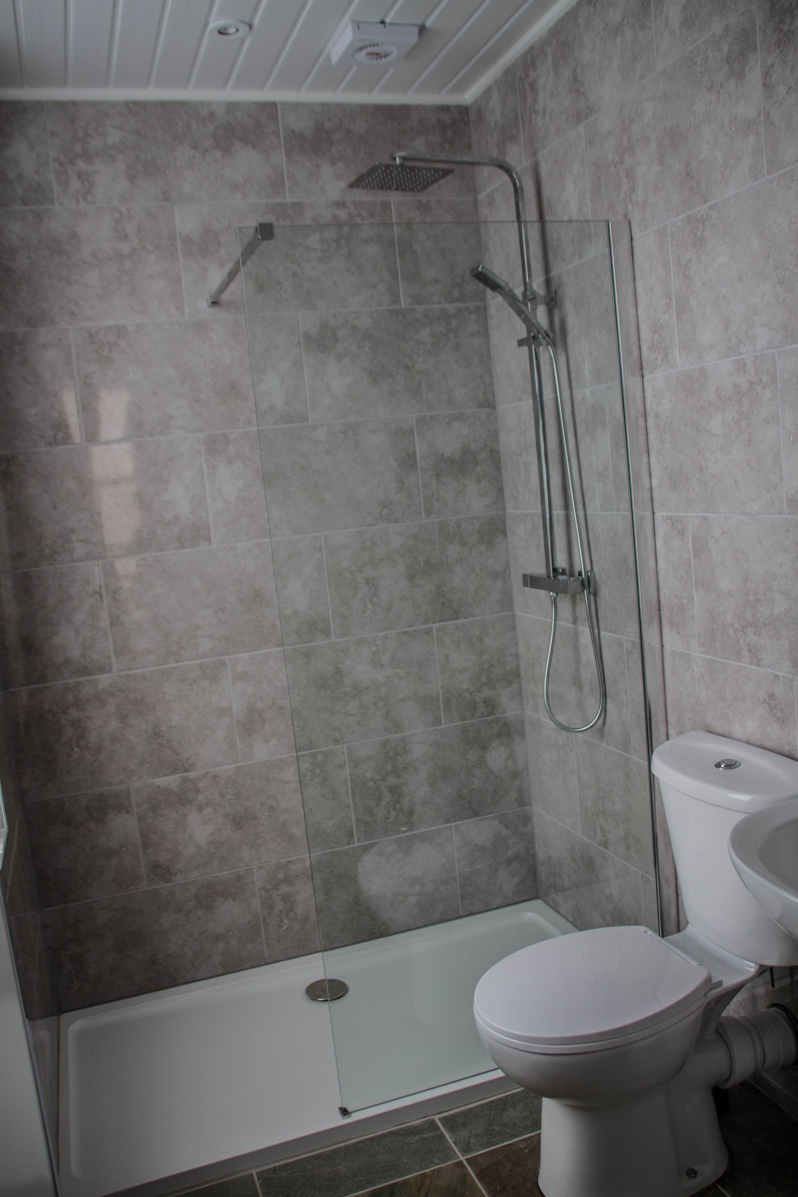 A bathroom with a shower, toilet, and sink.