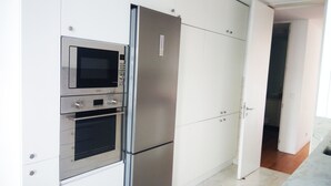 Una cocina equipada con electrodomésticos integrados, incluyendo un microondas, horno y refrigerador.