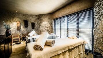 Relax in a cozy space with a large bed, window, and stool, perfect for unwinding.