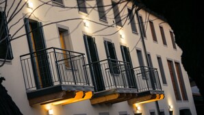 A multi-story building with balconies and exterior lighting. - Agriturismo Mestroni (Campoformido)