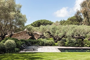 A stone bridge, lush greenery, and a swimming pool. - Domaine Les Mésanges (Gassin)