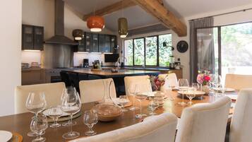 Un comedor con una mesa de madera dispuesta para una comida, rodeada de sillas.