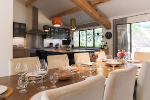 A dining area with a wooden table set for a meal, surrounded by chairs. - Domaine Les Mésanges (Gassin)