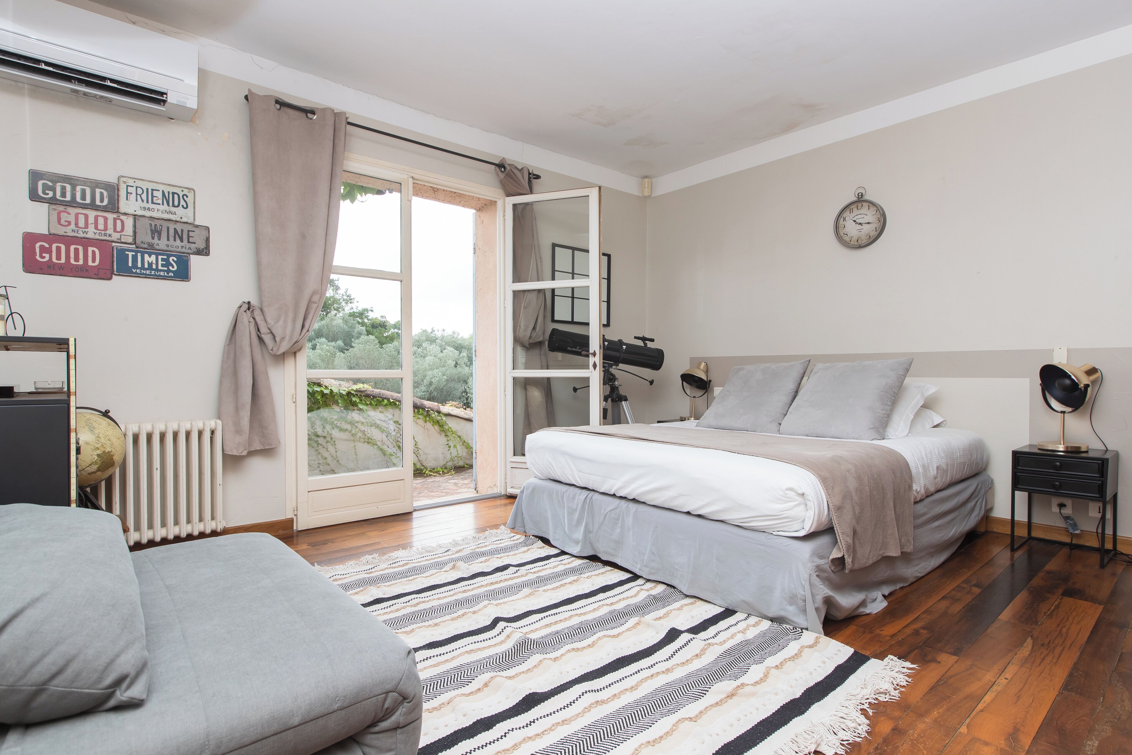 Un dormitorio con cama, escritorio, un globo terráqueo y una ventana con cortinas.