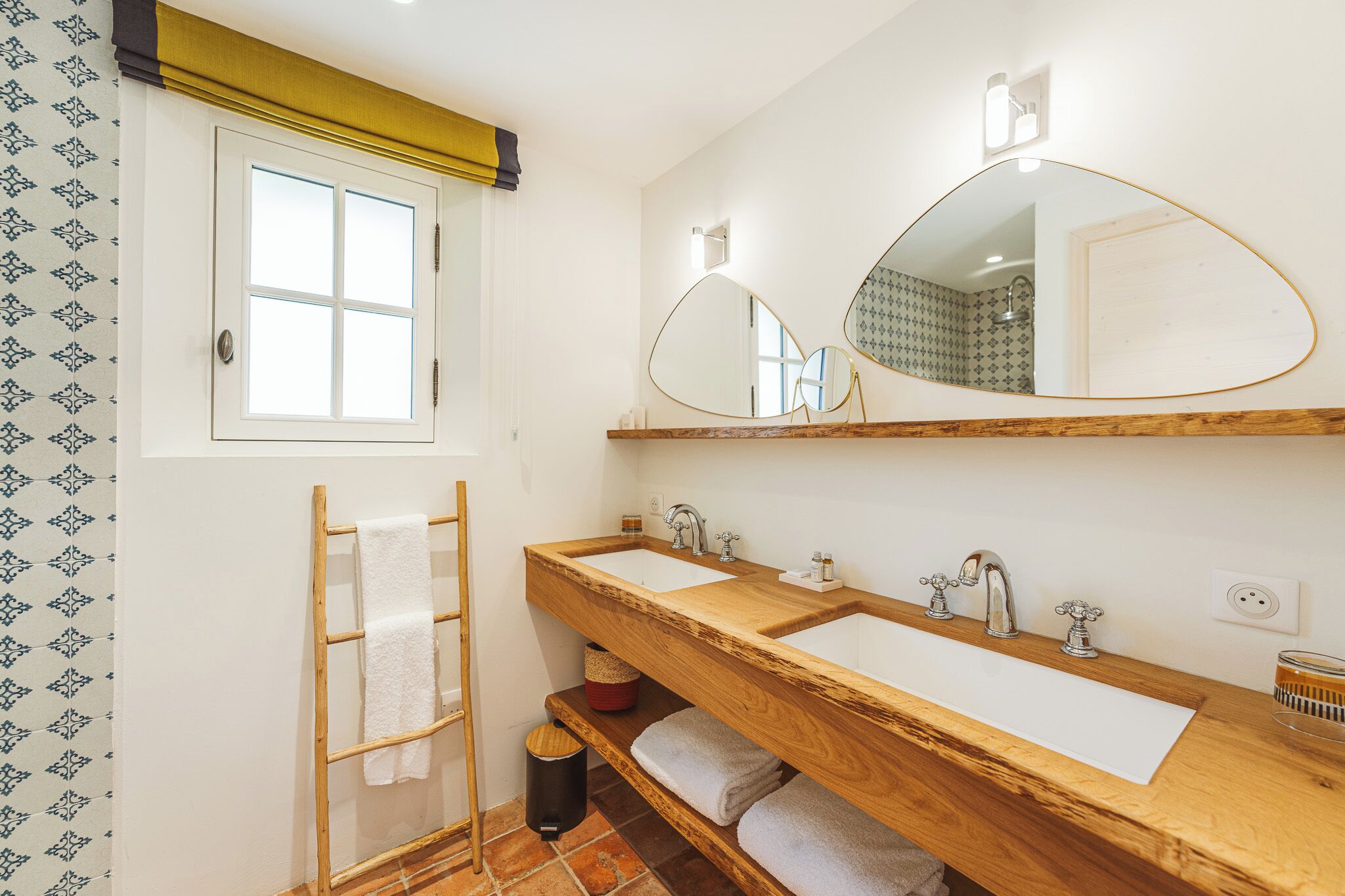 A bathroom with two sinks, a large mirror, and a towel rack.