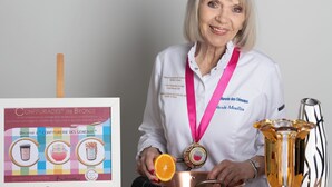 A person seated at a table with a trophy, a framed certificate, and a fruit bowl. - Domaine Les Mésanges (Gassin)