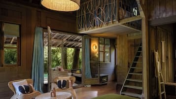 Un interno in legno con mobili in vimini, una scala e un balcone.