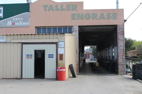 En byggnad med skylten ”TALLER ENGRASE” och en annan skylt som visar ”AREA Sandino”.