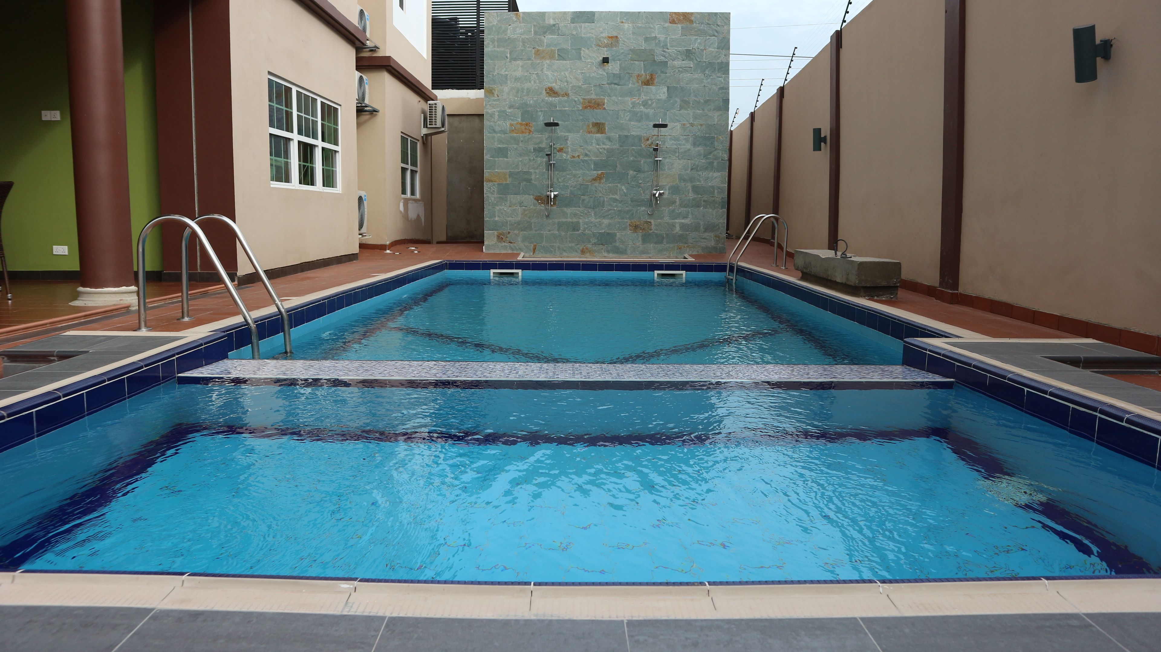 室外游泳池，開放時間為 06:00 至 19:00，提供泳池遮陽傘和日光浴躺椅