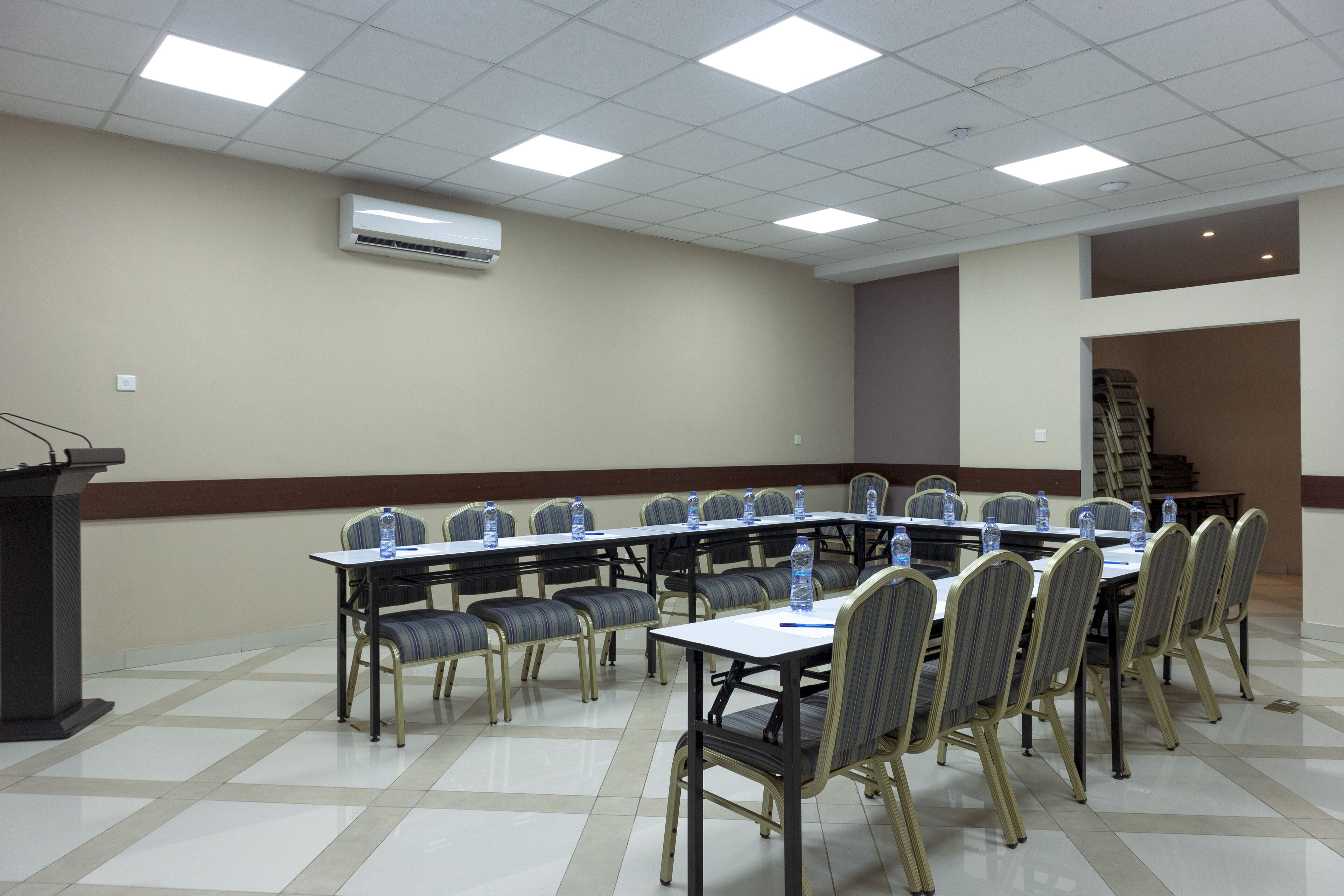 A conference room with a long table, chairs, and an air conditioning unit on the wall.