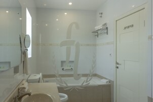 Un baño con lavamanos, espejo e inodoro.