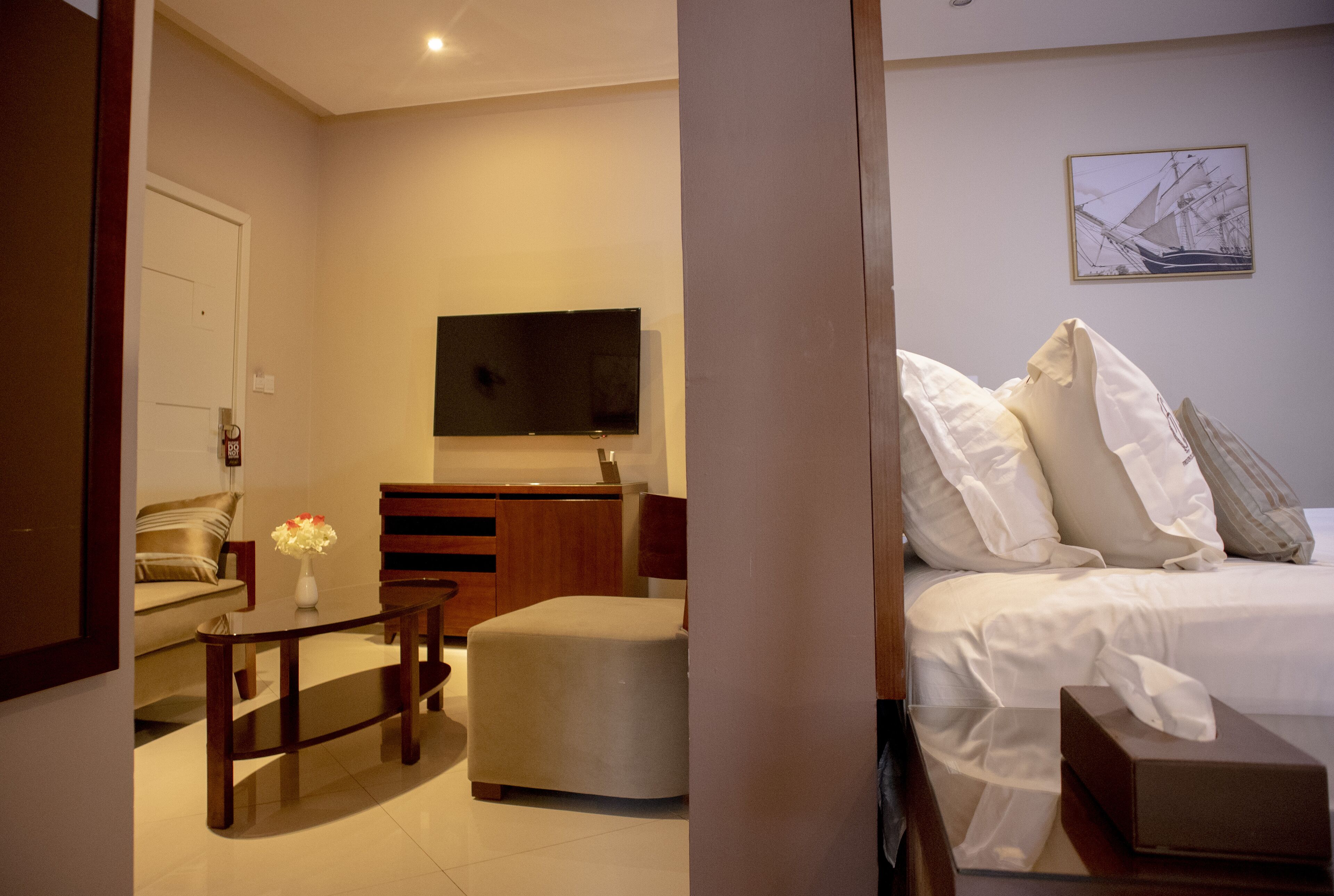 Una habitación de hotel con cama, televisor, escritorio y sofá.