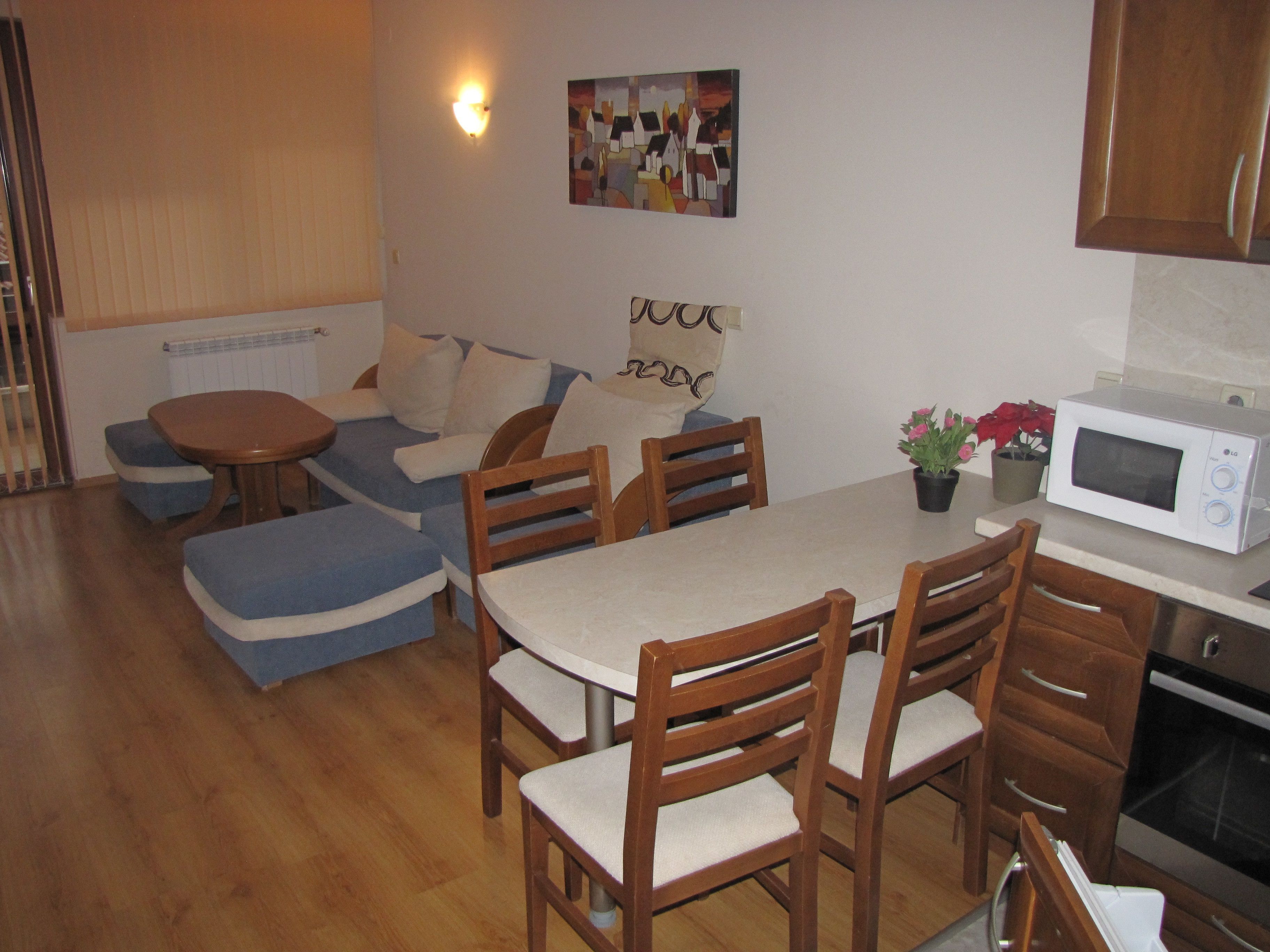 Een knus woongedeelte met een eethoek, kitchenette en een bank.