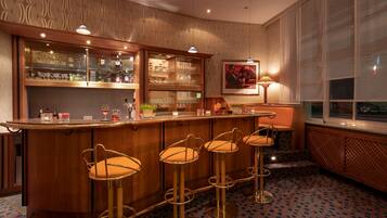 A bar area with a wooden counter, glass display cases, and four bar stools.