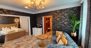 Un dormitorio con cama, sofá, mesa redonda de madera y armario.