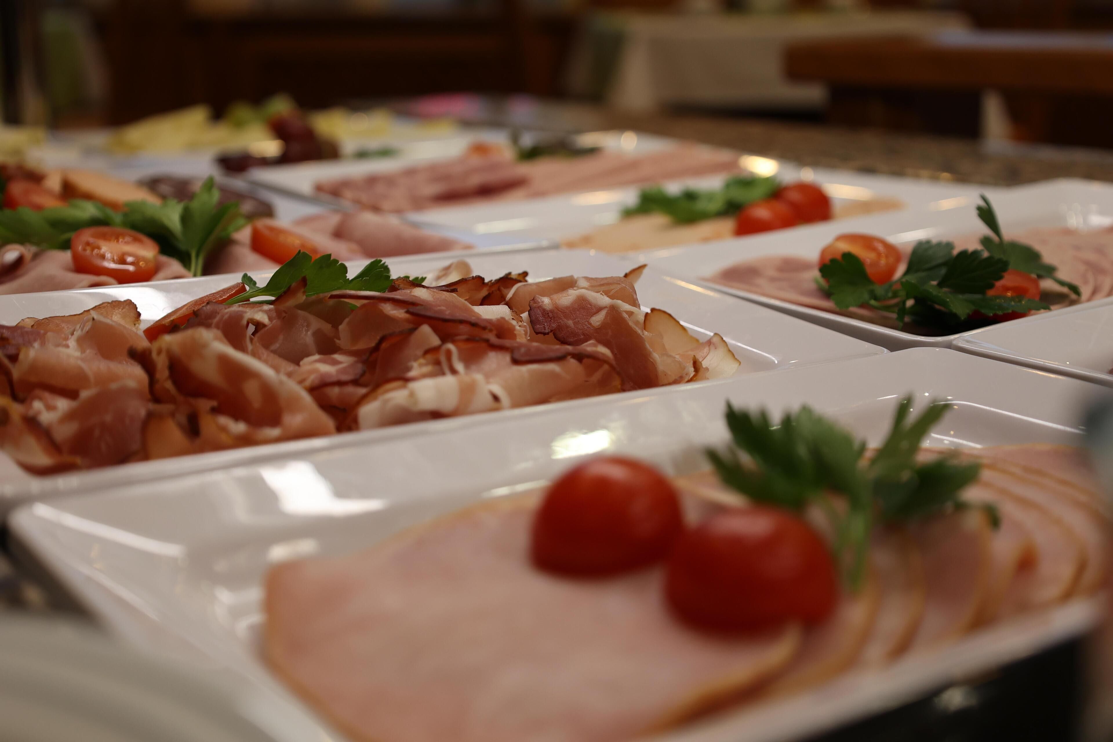 Un bufé con diferentes carnes y acompañamientos.