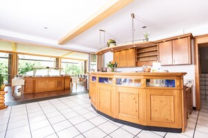Cozinha espaçosa com armários de madeira, uma ilha sinuosa e uma grande janela que oferece luz natural.