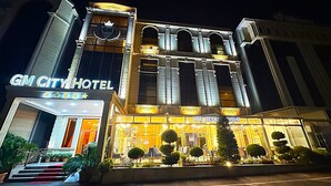 Un hotel con un cartel llamativo que dice "GM CITY HOTEL".
