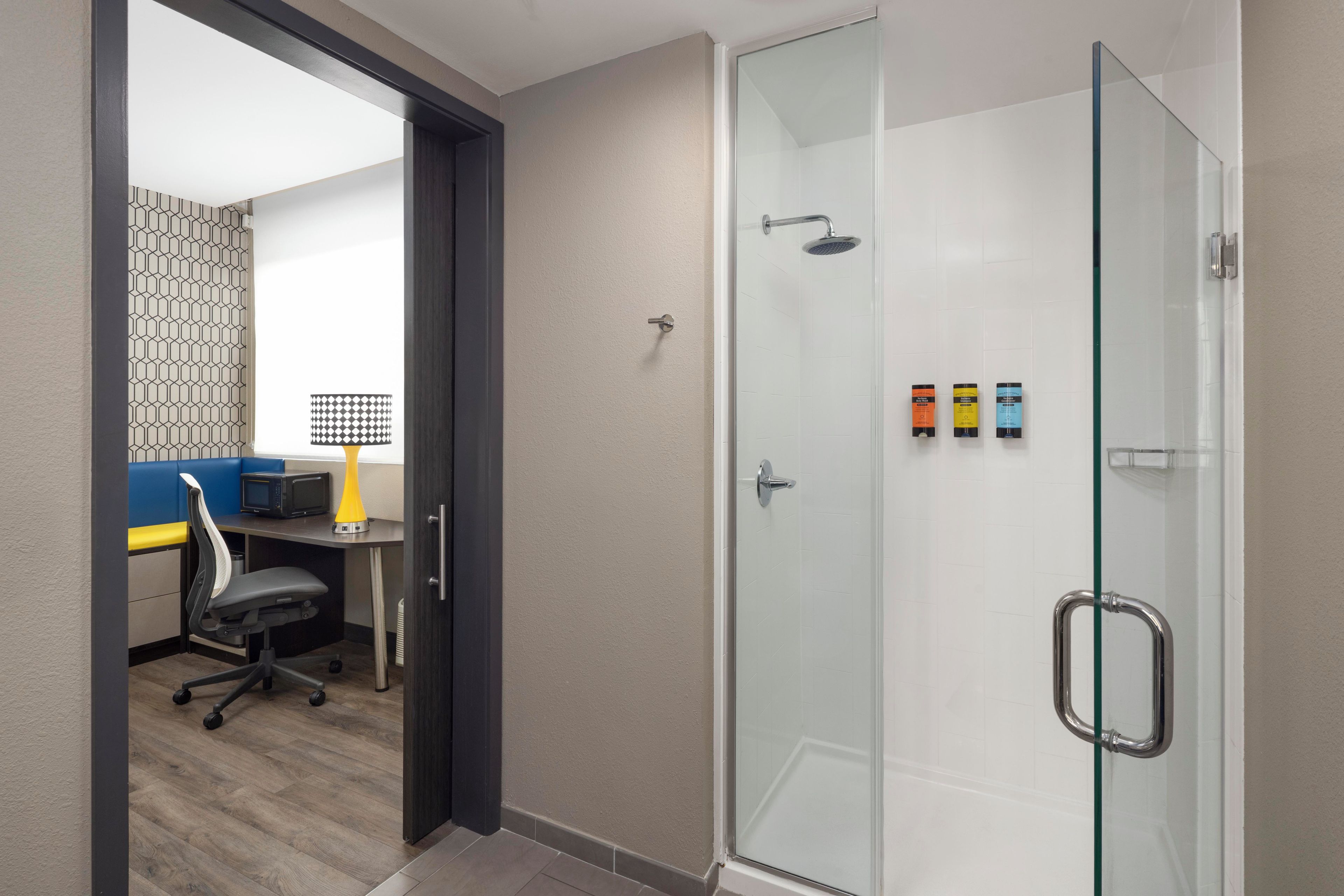 A modern bathroom with a glass shower enclosure, a toilet, and a sink.