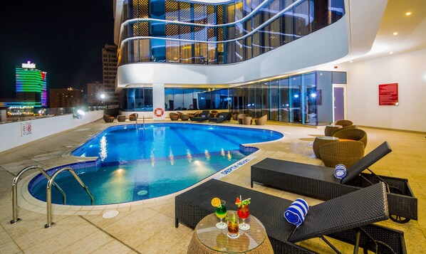 Een buitenzwembad en ligstoelen