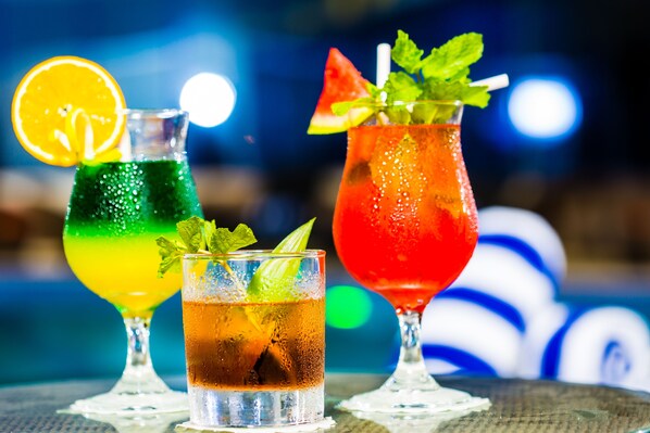 Three cocktails in different glasses with garnishes, set on a table.