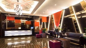 A modern lobby with a reception desk, leather seating, and a chandelier. - Best Western Senayan (Jakarta)