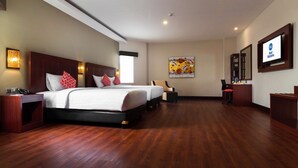 A spacious hotel room with a large bed, two bedside tables, a chair, a desk, and a TV. - Best Western Senayan (Jakarta)