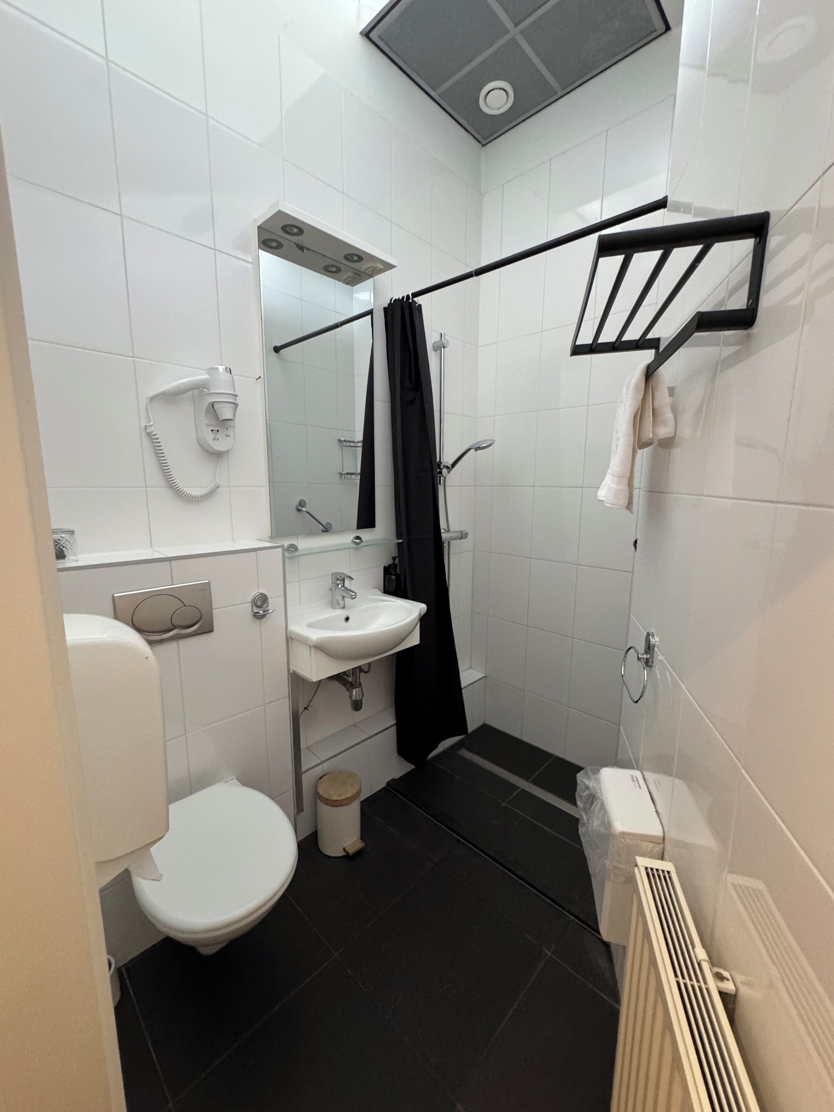 A modern bathroom with a toilet, sink, and shower.