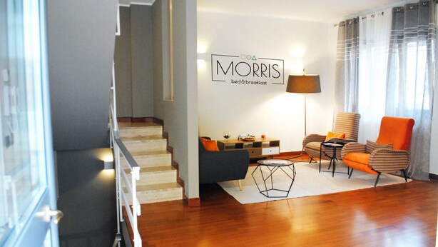 Ein modernes Wohnzimmer mit Treppe, Sofa, Couchtisch und Lampe.