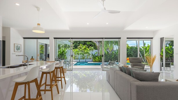 Cozinha moderna com área de bar, uma janela grande e vista para uma piscina.