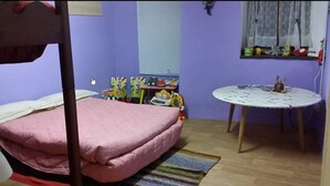 A room with a bunk bed, a small table with a decorative item, and a window with curtains. - Relais des Alpes (Giaglione)