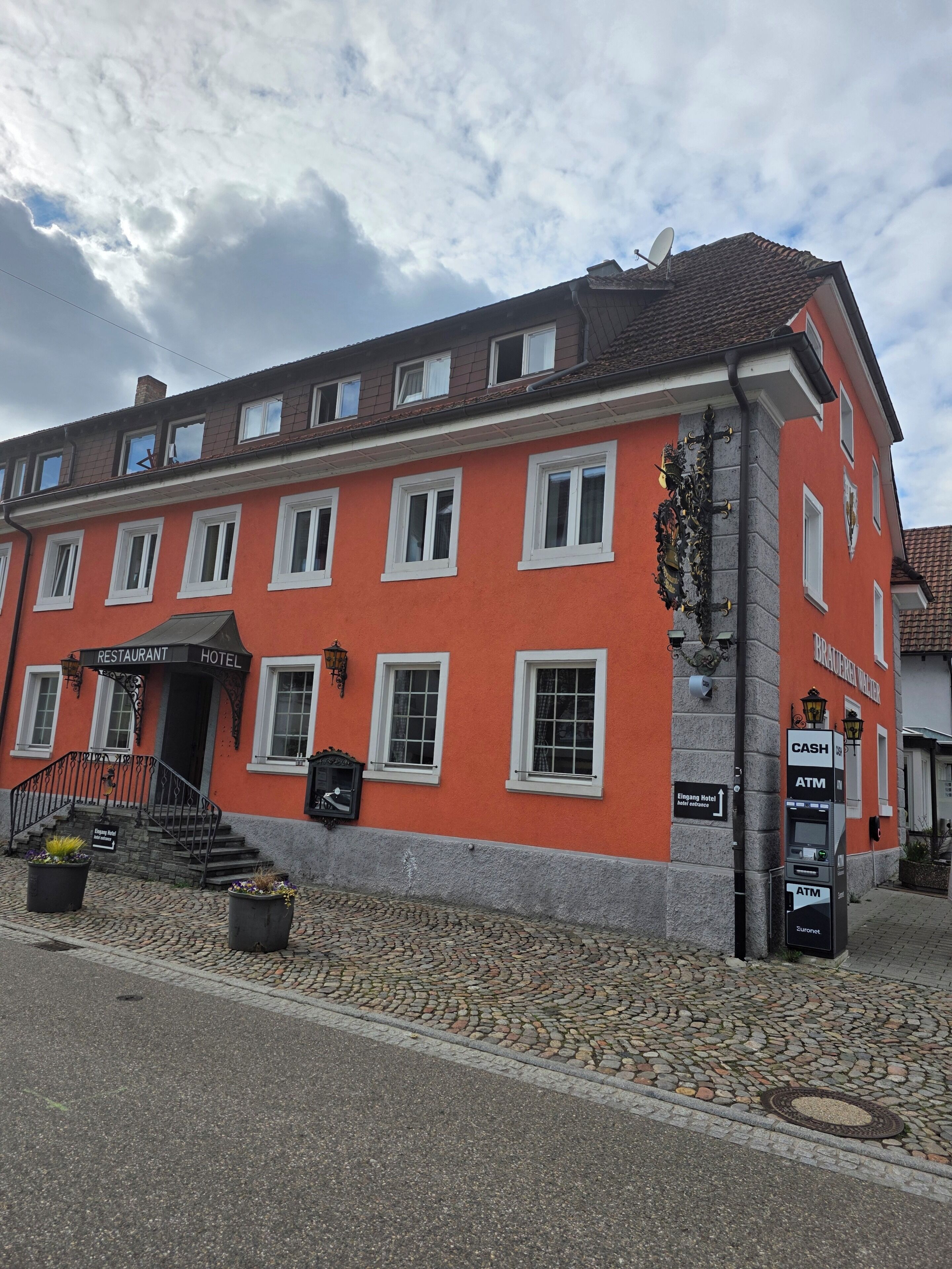 Un edifici vermell amb un rètol que indica que és un restaurant i un hotel.