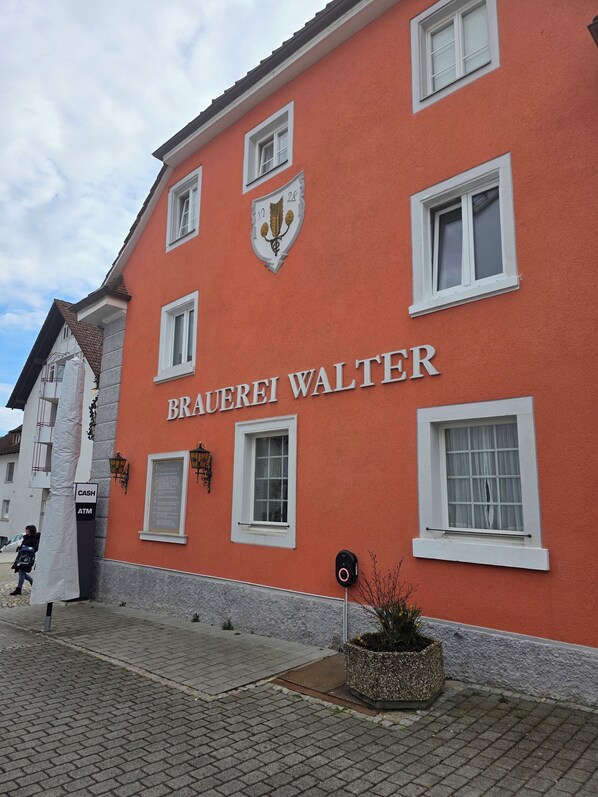 Un bâtiment dont la façade porte l’inscription « BRAUEREI WALTER », avec de nombreuses fenêtres et un petit balcon.