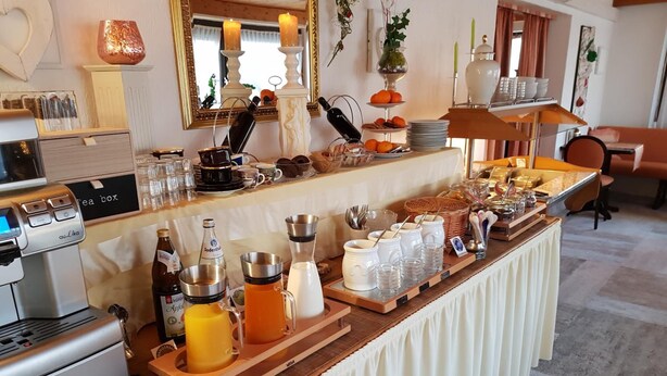 A breakfast buffet with coffee machines, tea boxes, and various food items. - Hotel Irene (Bad Konig)