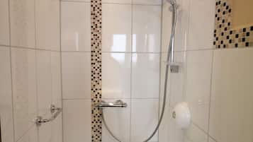 A bathroom with a shower, a toilet, and a bathtub.