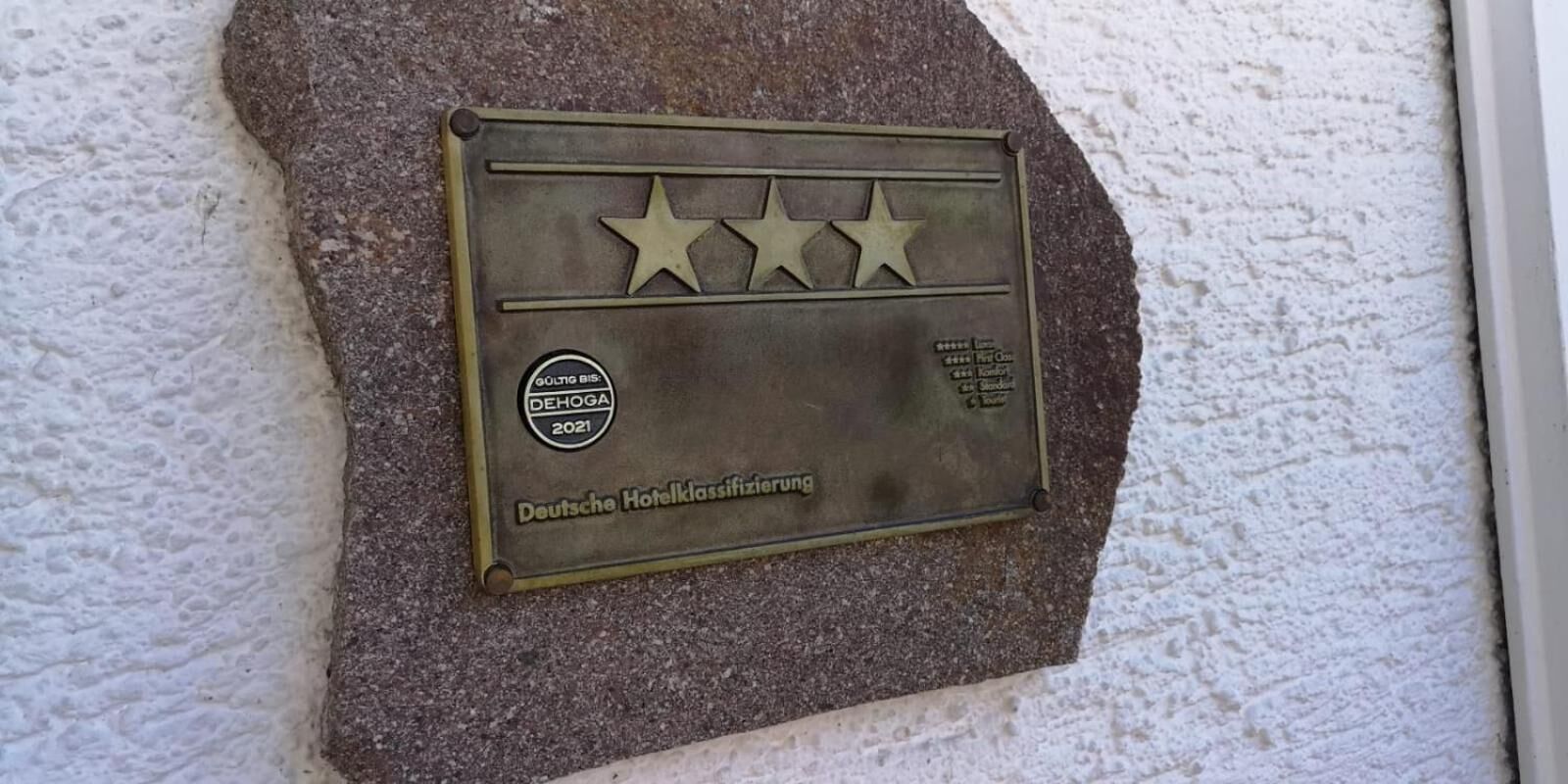 A plaque with three stars and text indicating it is a DEHOGA 2021 award from Deutsche Hotelklassifizierung.
