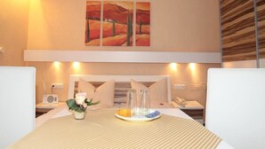 A hotel room with a bed, bedside table, lamp, and a painting on the wall. - Hotel Irene (Bad Konig)