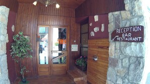 Una barra de recepción y restaurante con puertas de madera y paredes de piedra.