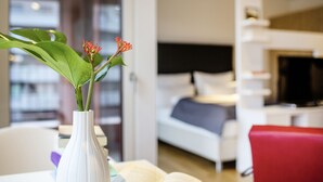 A modern hotel room with a bed, a TV, and a red chair. - THE FLAG Oskar M. (Frankfurt)