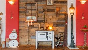A room with a wooden wall, a white cabinet, a wine rack, and a floor lamp. - Hotel Bergschlösschen (Jueterbog)