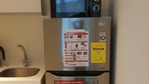 A stainless steel refrigerator with a built-in microwave and a Smart Inverter Compressor. - 2 BR Condo by JAD at Azure Urban Resort Residences (Parañaque)