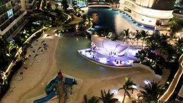 A hotel with a pool, a children's play area, and a beach.