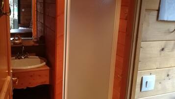 A wooden bathroom with a sink, mirror, and a towel rack.