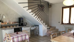 A modern kitchen with a staircase, wooden dining table, and chairs. - La Bella Vigna (Marano di Valpolicella)
