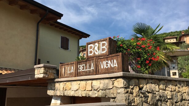 A stone wall with a wooden signboard displaying "B&B La Bella Vigna". - La Bella Vigna (Marano di Valpolicella)
