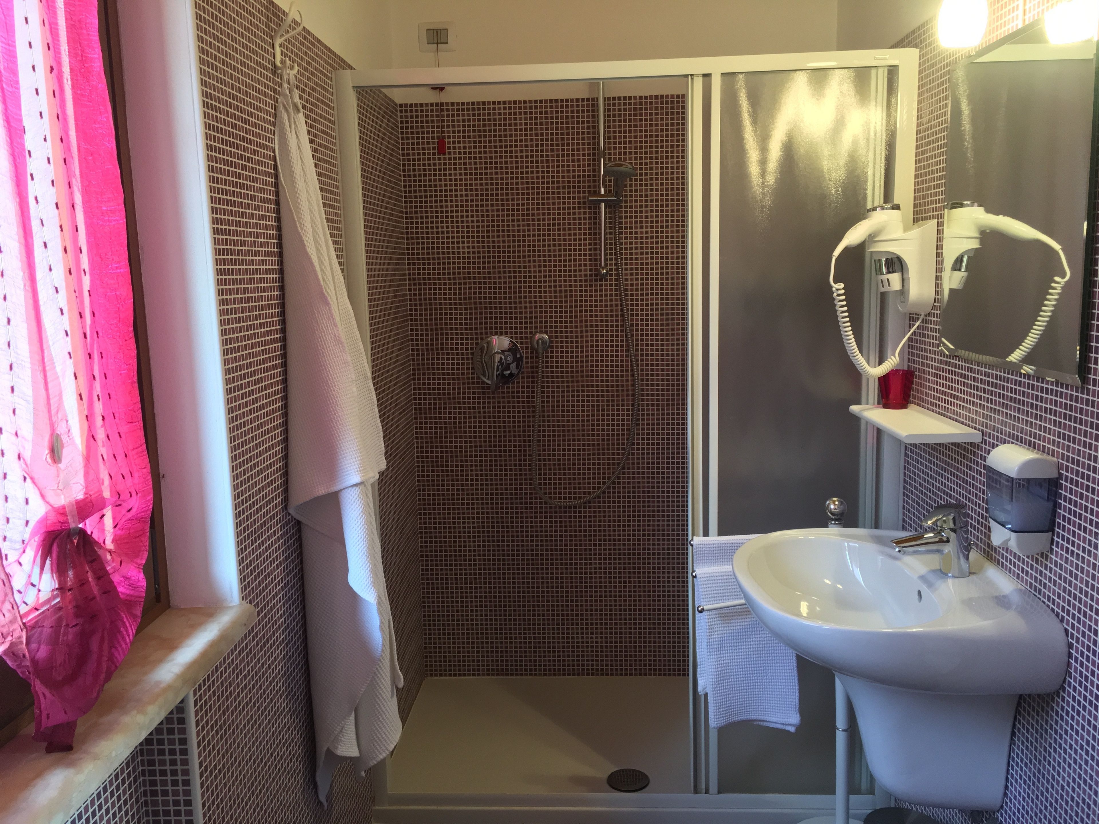 Un baño con ducha, lavabo y espejo.