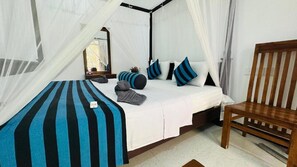 A bedroom with a bed, a chair, a bedside table, and a mirror. - Sigiriya Danu homestay (Sigiriya)