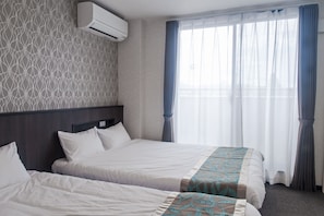 A hotel room with two beds, a patterned wall, an air conditioning unit, and a large window with curtains. - UU Inn Fushimi Kyoto (Kyoto)